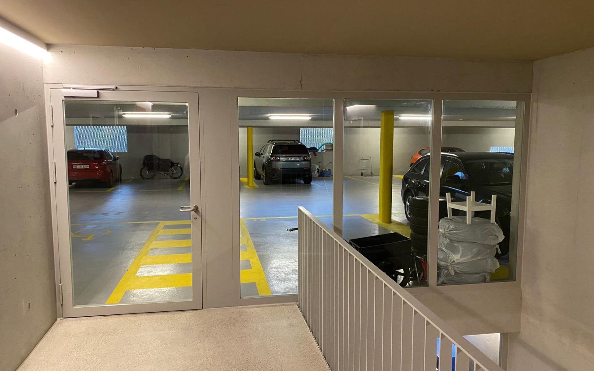 Cloison vitrée avec porte d’accès à un parking souterrain
